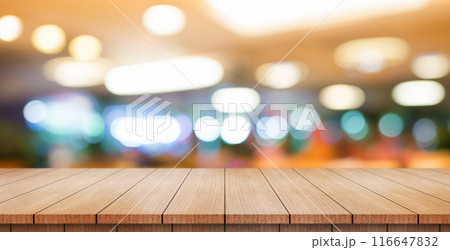 Empty wooden table top with lights bokeh on blur restaurant background. Empty wooden table top with lights bokeh on blur restaurant background. 116647832