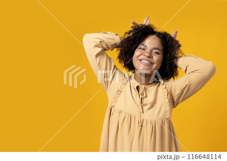 Young attractive African American woman dancing on yellow background 116648114