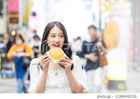 観光をしながら食べ歩きをする若い女性 観光をしながら食べ歩きをする若い女性 116648150