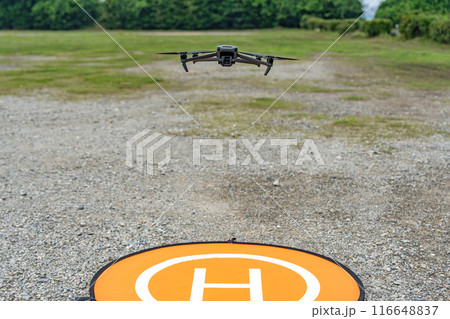 ホバリングするドローンとランディングパッド 116648837
