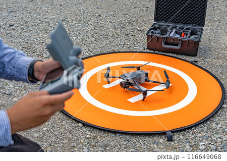 ランディングパッド上のドローン　コントローラーを持つ男性 116649068