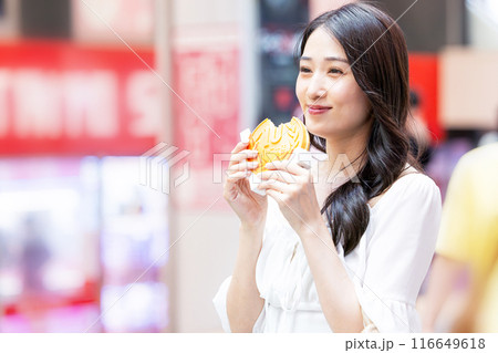 観光をしながら食べ歩きをする若い女性 観光をしながら食べ歩きをする若い女性 116649618