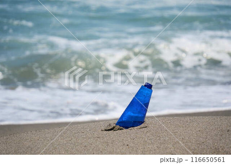 波が打ち寄せる砂浜と青いボトル 116650561
