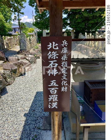 ずらりと並んだ色々な顔の石仏、加西市の北条の五百羅漢ごひゃくらかんの看板 116652186