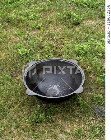 An empty cast iron cauldron stands on green grass. An empty cast iron cauldron stands on green grass. 116652256