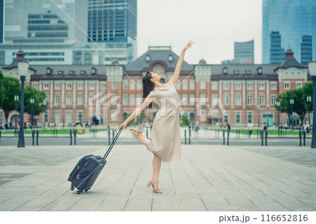 キャリーバッグをひいて旅にでた、若い女性心弾む様子 キャリーバッグをひいて旅にでた、若い女性心弾む様子 116652816
