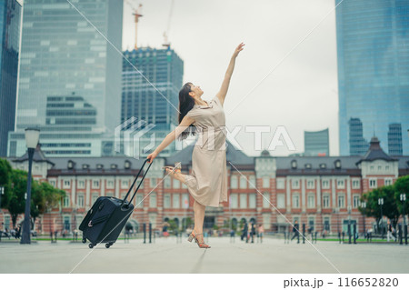 キャリーバッグをひいて旅にでた、若い女性心弾む様子 116652820