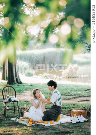 ピクニックをしながら前撮り撮影をする新郎新婦 ピクニックをしながら前撮り撮影をする新郎新婦 116652912