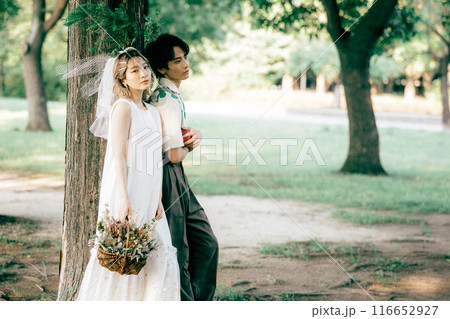 ピクニックをしながら前撮り撮影をする新郎新婦 116652927
