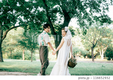 ピクニックをしながら前撮り撮影をする新郎新婦 116652932