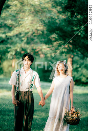 ピクニックをしながら前撮り撮影をする新郎新婦 116652943