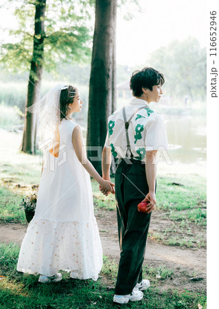 ピクニックをしながら前撮り撮影をする新郎新婦 116652946