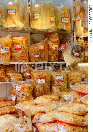 香港・徳輔道西の高級乾物店で売られる魚の高級食材の浮き袋（魚膠）の上で店番をするネコ 116653564