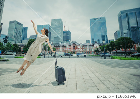 キャリーバッグをひいて旅にでた、若い女性の心弾む様子 キャリーバッグをひいて旅にでた、若い女性の心弾む様子 116653946