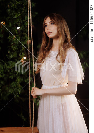 Elegant woman on wooden swing. 116654327