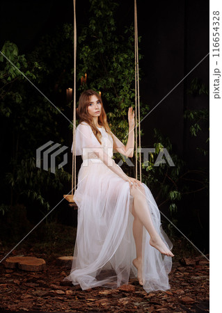 Elegant woman on wooden swing. Elegant woman on wooden swing. 116654328