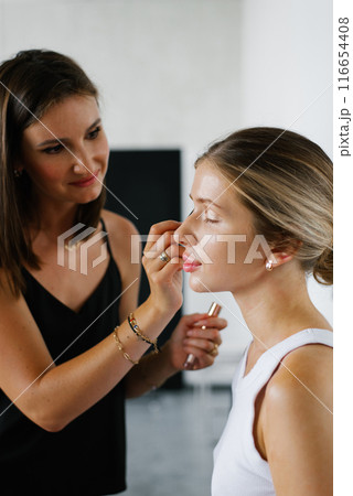 Professional makeup artist doing makeup for girl Professional makeup artist doing makeup for girl 116654408