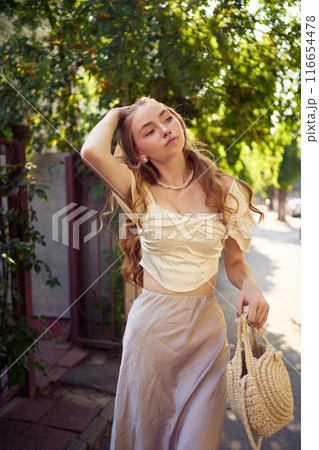 beautiful teenage girl in a silk skirt and a corset in the old money style strolls through the city beautiful teenage girl in a silk skirt and a corset in the old money style strolls through the city 116654478