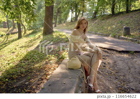 beautiful teenage girl in a silk skirt and a corset in the old money style walks in the park and along the river bank beautiful teenage girl in a silk skirt and a corset in the old money style walks in the park and along the river bank 116654622