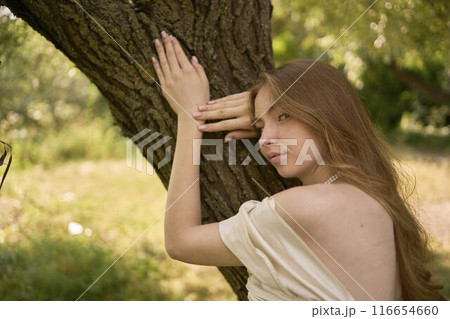 beautiful teenage girl in a silk skirt and a corset in the old money style walks in the park and along the river bank beautiful teenage girl in a silk skirt and a corset in the old money style walks in the park and along the river bank 116654660