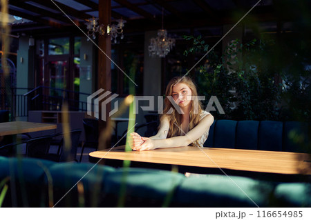 a  beautiful teenage girl in a peach fuzz suit with a vest, in the old money style in a fancy restaurant 116654985