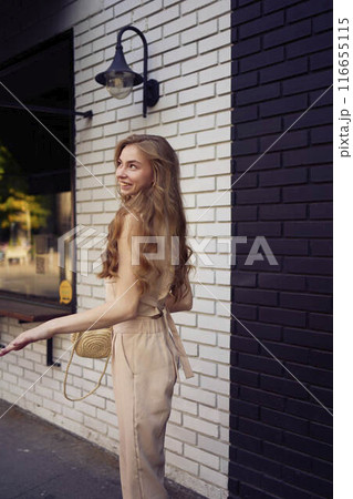 a beautiful teenage girl in a peach fuzz suit with a waistcoat, in the old money style walks through the morning city a beautiful teenage girl in a peach fuzz suit with a waistcoat, in the old money style walks through the morning city 116655115