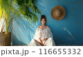 夏らしい雰囲気の部屋で座って微笑む白い服の女性 116655332