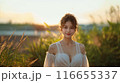 夕日に照らされる優しい雰囲気で微笑む女性 116655337