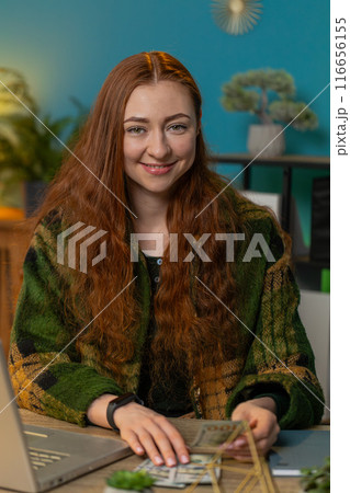 Business woman counting money cash and using laptop calculates dividends profits finances at office Business woman counting money cash and using laptop calculates dividends profits finances at office 116656155
