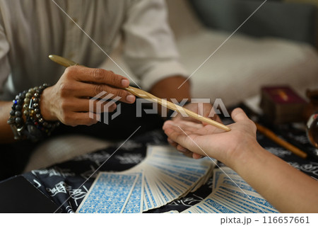 Close up fortune teller reading palm forecasting future of client in dark room. Divination concept 116657661