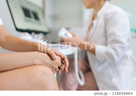 Closeup cropped shot of nervous female patient listening physician explaining clinic examination. Practitioner doctor providing medical consultation at healthcare visit at table with computer Closeup cropped shot of nervous female patient listening physician explaining clinic examination. Practitioner doctor providing medical consultation at healthcare visit at table with computer 116659464