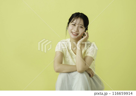 黄色背景の花を持つ若い女性のポートレート 黄色背景の花を持つ若い女性のポートレート 116659914