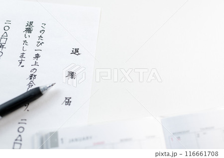 白い机の上に置かれた手書きの退職届と黒色のゲルインクペン 116661708