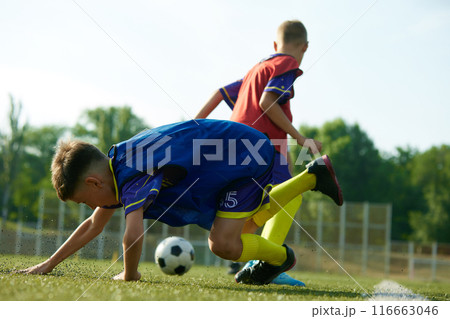 Young players improve their techniques, children in red and blue uniforms, soccer players in motion on outdoor stadium training Young players improve their techniques, children in red and blue uniforms, soccer players in motion on outdoor stadium training 116663046