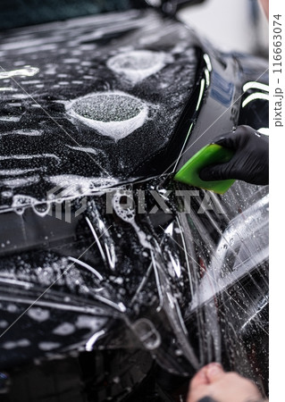 Detailing car wheel using brush for thorough cleaning. 116663074