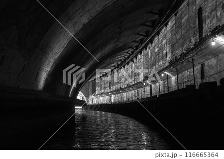 Turning concrete tunnel. Abandoned underground submarine base 116665364