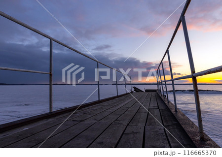 Old pier is under sunset sky in the evening, perspective view 116665370