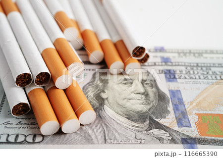 Cigarette on US dollar banknotes, cost, trading, marketing and production, No smoking concept. Cigarette on US dollar banknotes, cost, trading, marketing and production, No smoking concept. 116665390