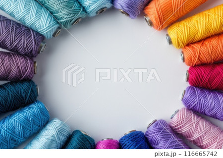 Colorful thread spools forming a circle. Colorful thread spools forming a circle. 116665742