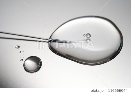 A drop of medicine flowing from a syringe with a needle. 116666044