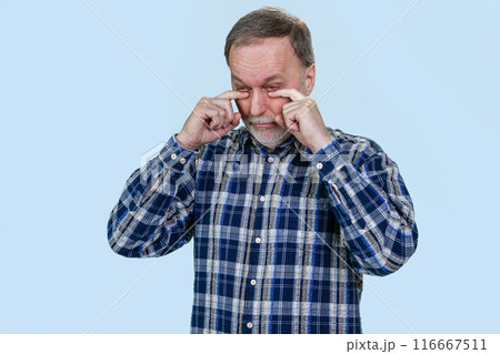 Portrait of sad crying aged senior caucasian man. Isolated on blue. Portrait of sad crying aged senior caucasian man. Isolated on blue. 116667511