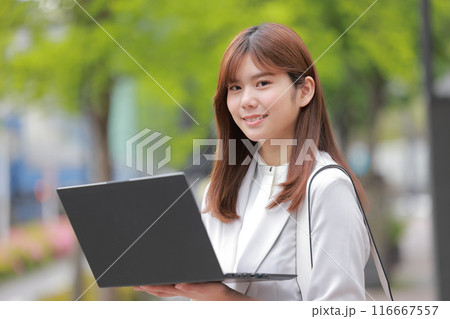 新緑の街でノートPCを開くビジネスウーマン_1 新緑の街でノートPCを開くビジネスウーマン_1 116667557