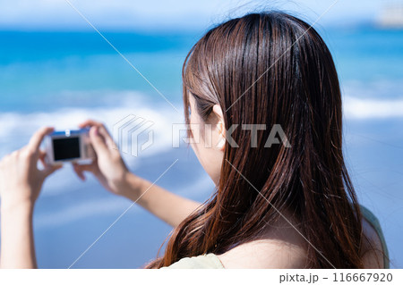 コンデジで海を撮影する女性 116667920