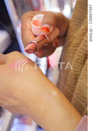 A gesture of applying carmine lipstick to the flesh of another persons hand A gesture of applying carmine lipstick to the flesh of another persons hand 116667987