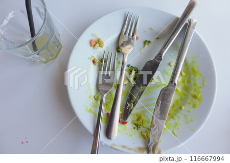 An empty dirty plate with a fork. 116667994