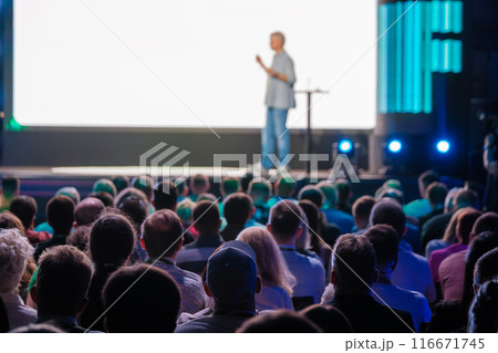 Speaker presenting to a large audience in a conference hall Speaker presenting to a large audience in a conference hall 116671745