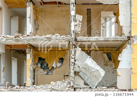 Partially demolished building with exposed interior walls and rubble 116671944