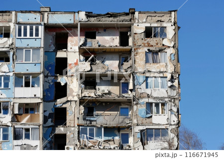 Damaged apartment building from conflict with blue sky 116671945