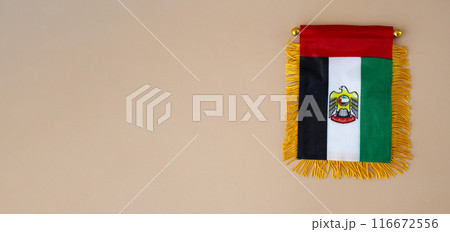 Small flag of UAE in beige background. Copy space. Mock up advertisement template. Tourism travel voucher with United Arab Emirates national symbol. Visit Dubai 116672556