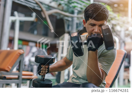 Asian man exercise heavy dumbbell weight bodybuilding in fitness. Asian man exercise heavy dumbbell weight bodybuilding in fitness. 116674281
